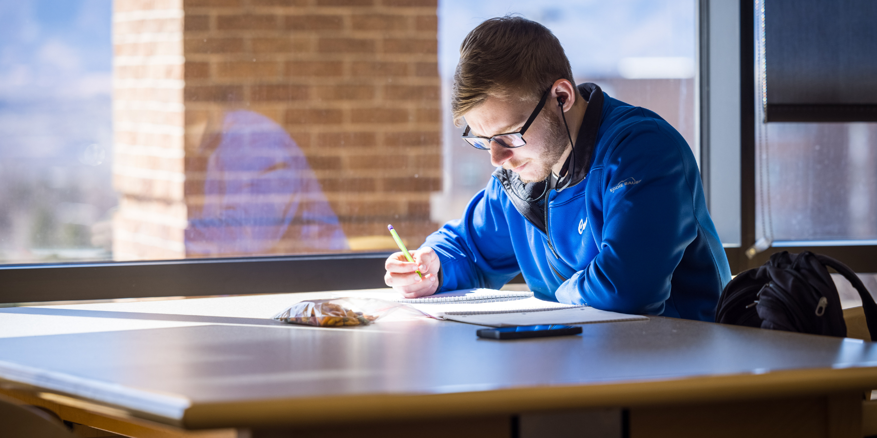 Photo of a business student studying at the library.