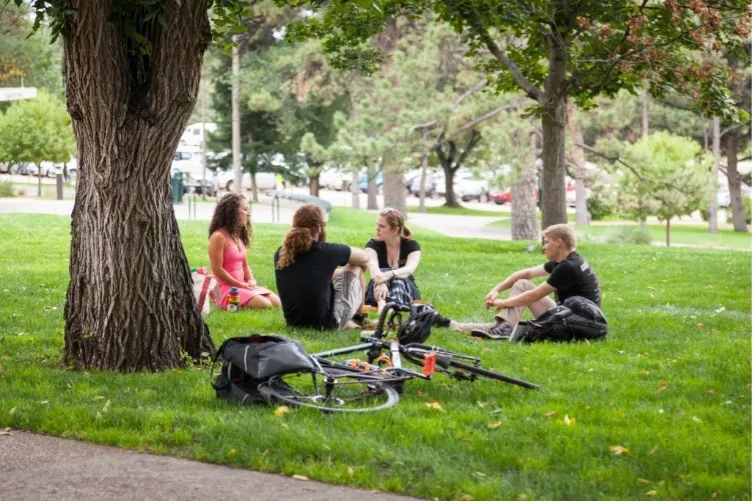 students sitting in front of the lawn in front of Main Hall